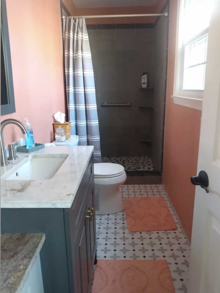 Tiled bathroom shower walls, pan, and floor.