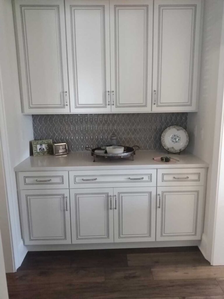 Bar area with white cabinets and quartz countertops.