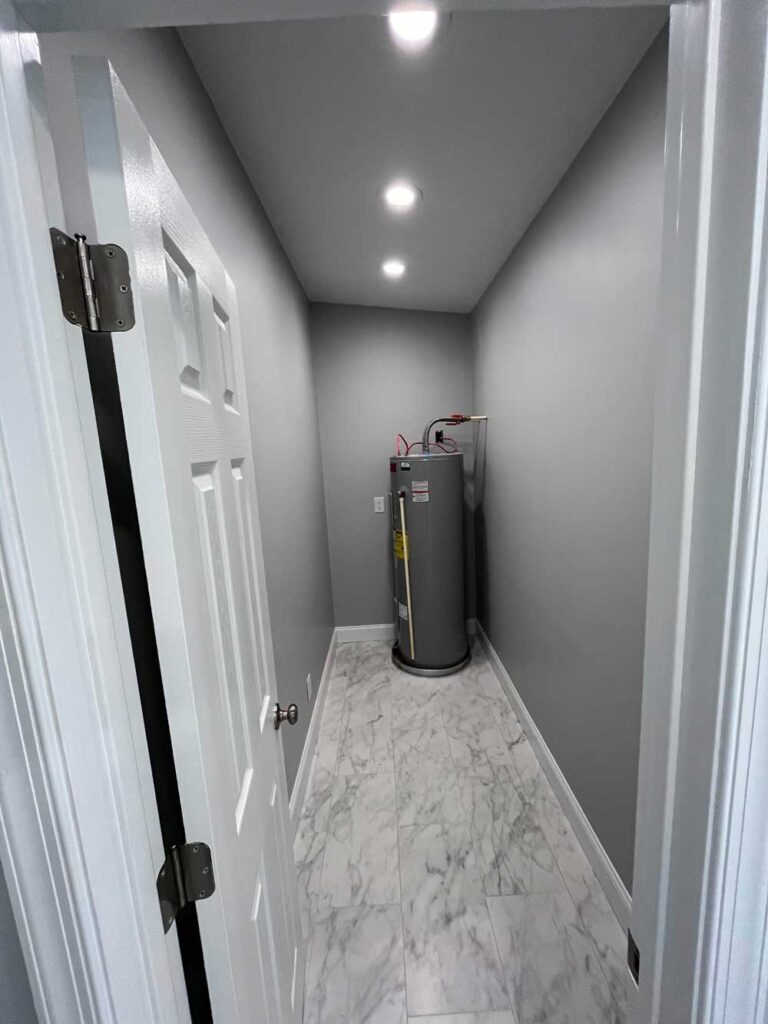 Bathroom closet with tiled floor and a water heater