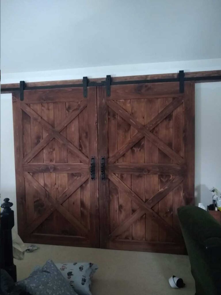 Double dark brown wood barn door with black hardware